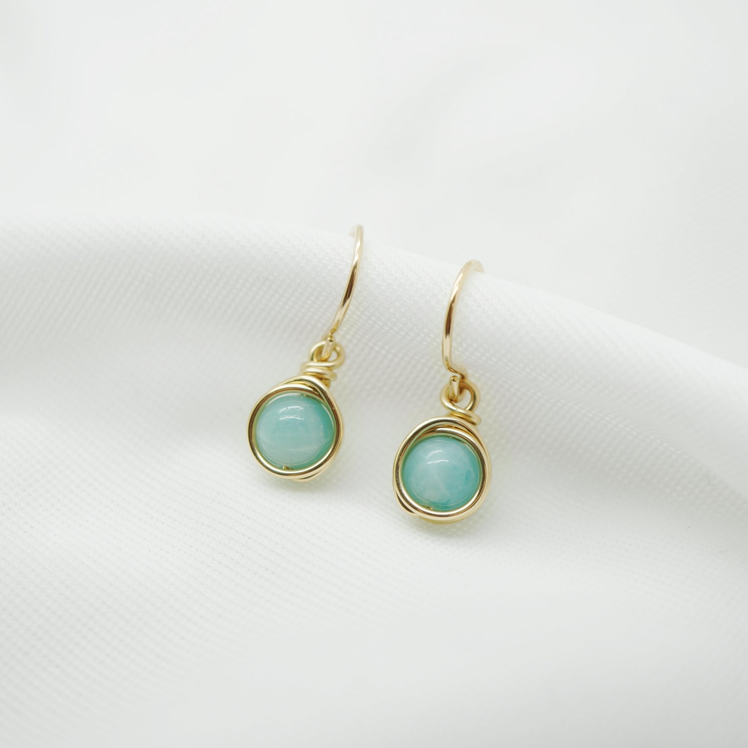 Elegante 14k gold filled wire wrap oorbellen met Amazoniet op witte achtergrond.