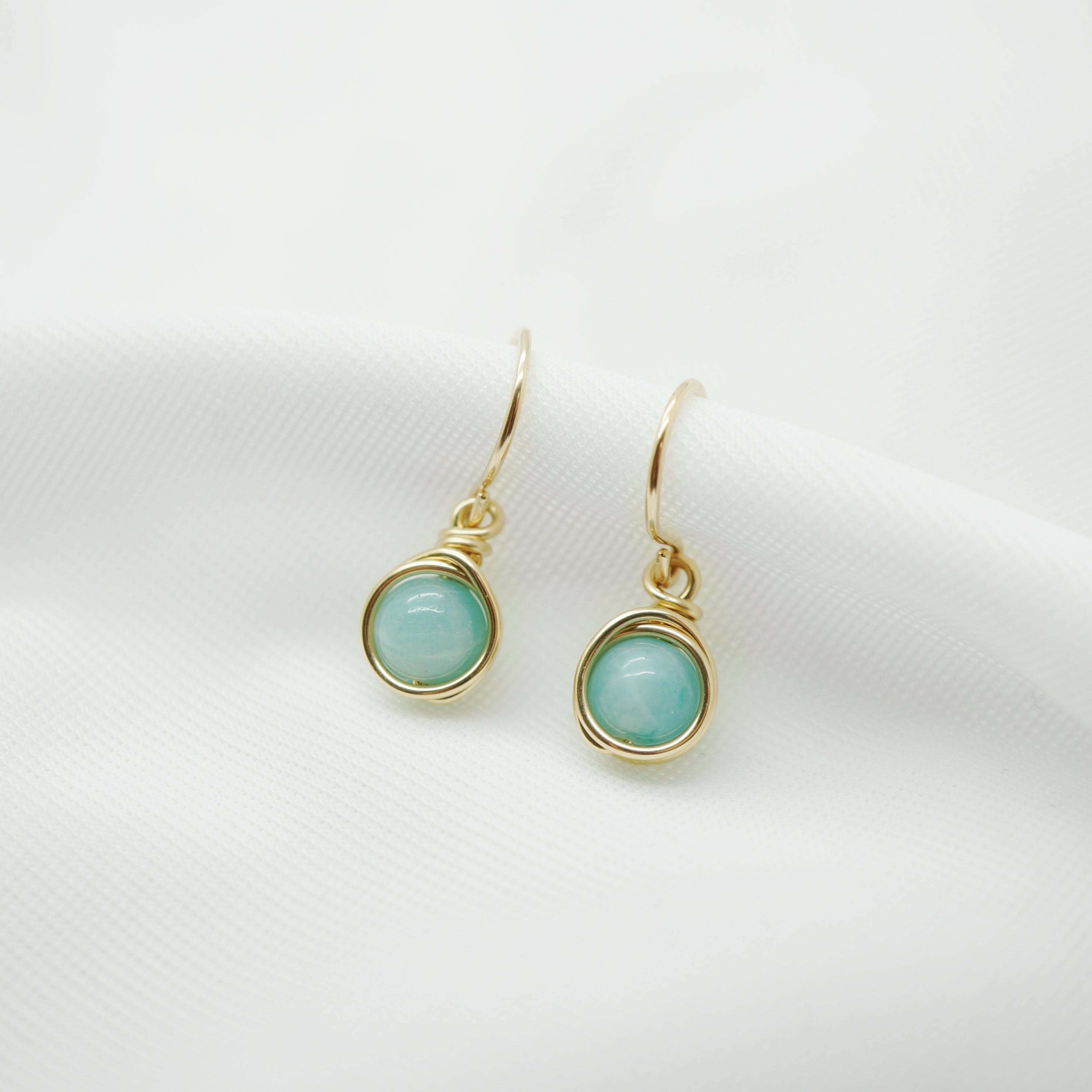 Elegante 14k gold filled wire wrap oorbellen met Amazoniet op witte achtergrond.