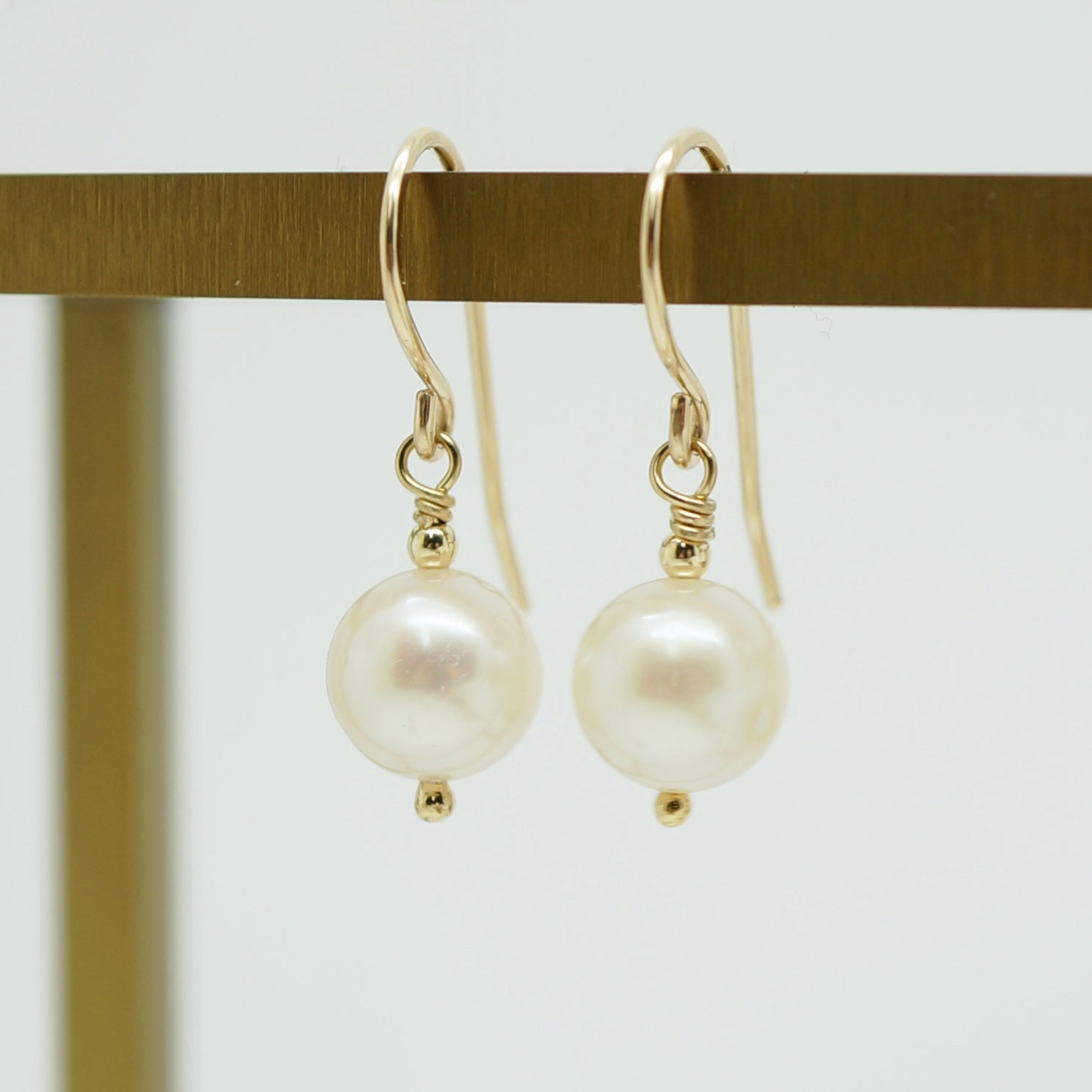 Klassieke handgemaakte 14k gold filled oorbellen met witte zoetwaterparel, elegant en tijdloos design.