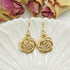 Close-up van handgemaakte 14k gold-filled oorbellen met roosmotief van Atelier Blaauw