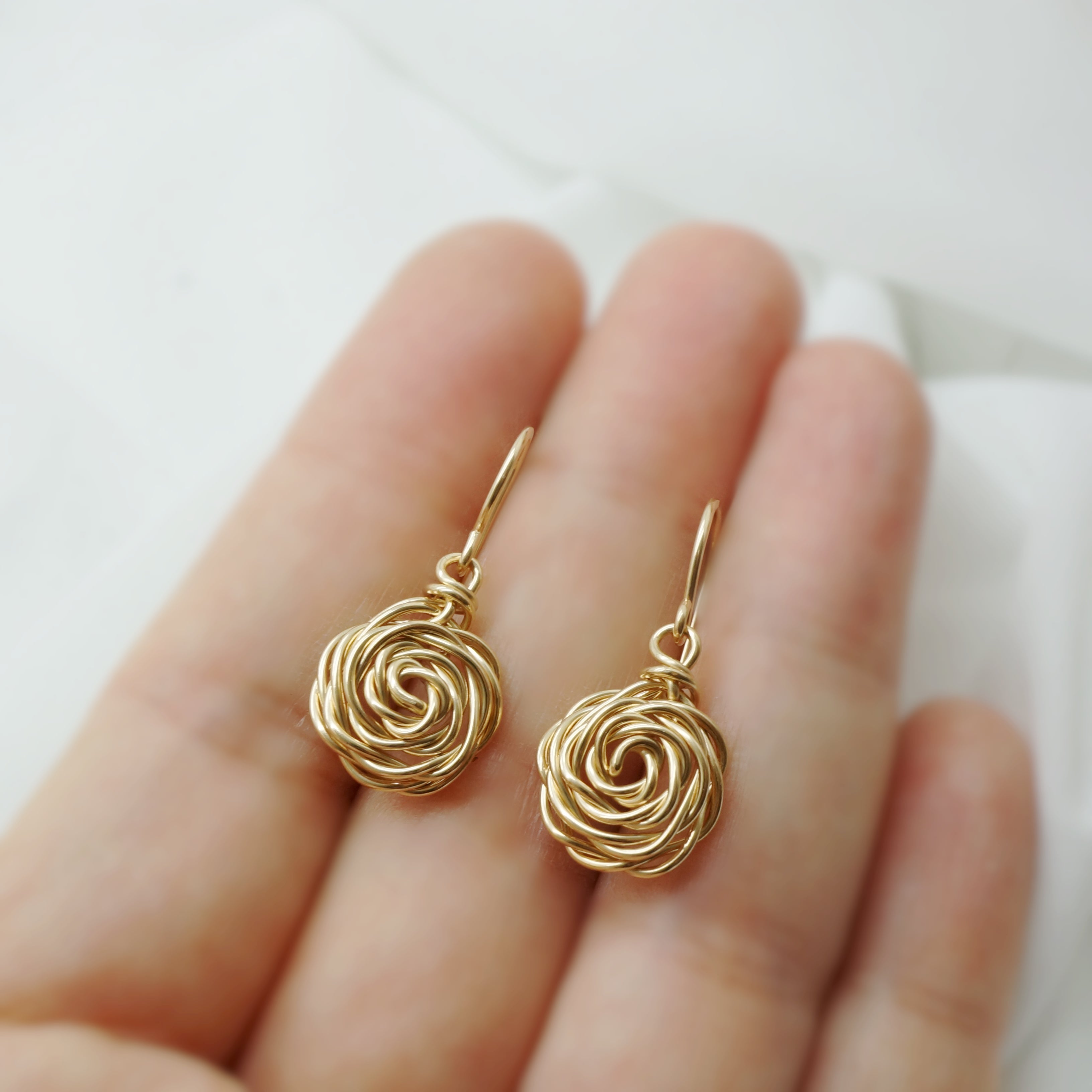 14k Gold-Filled Roos Oorbellen getoond op een hand – handgemaakt sieraad met elegante roosvorm, duidelijk zichtbare afmeting en fijne details.