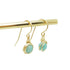 Close-up van 14k gold filled wire wrap oorbellen met Amazoniet steen, handgemaakt.