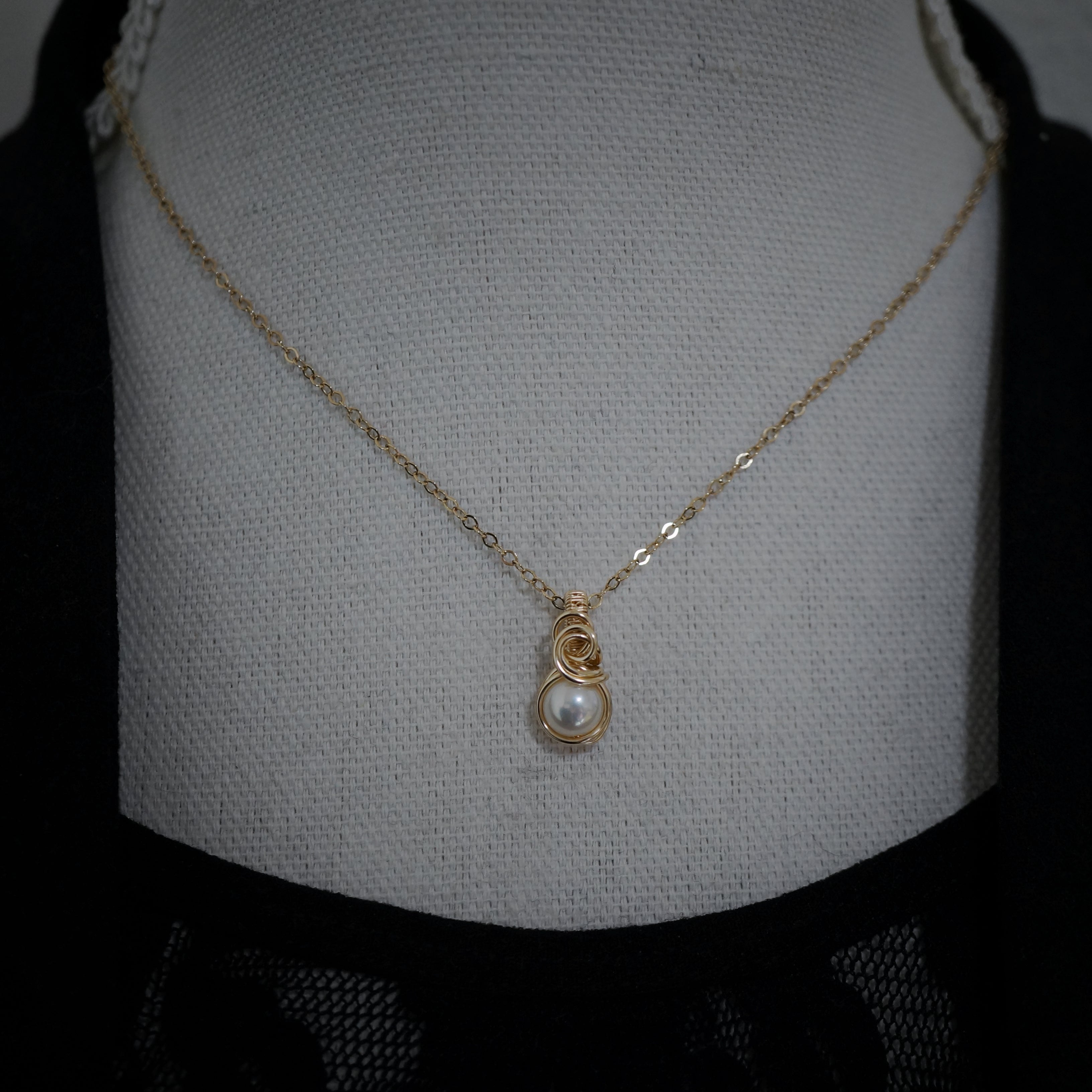 Gold filled parelhanger gefotografeerd op een buste