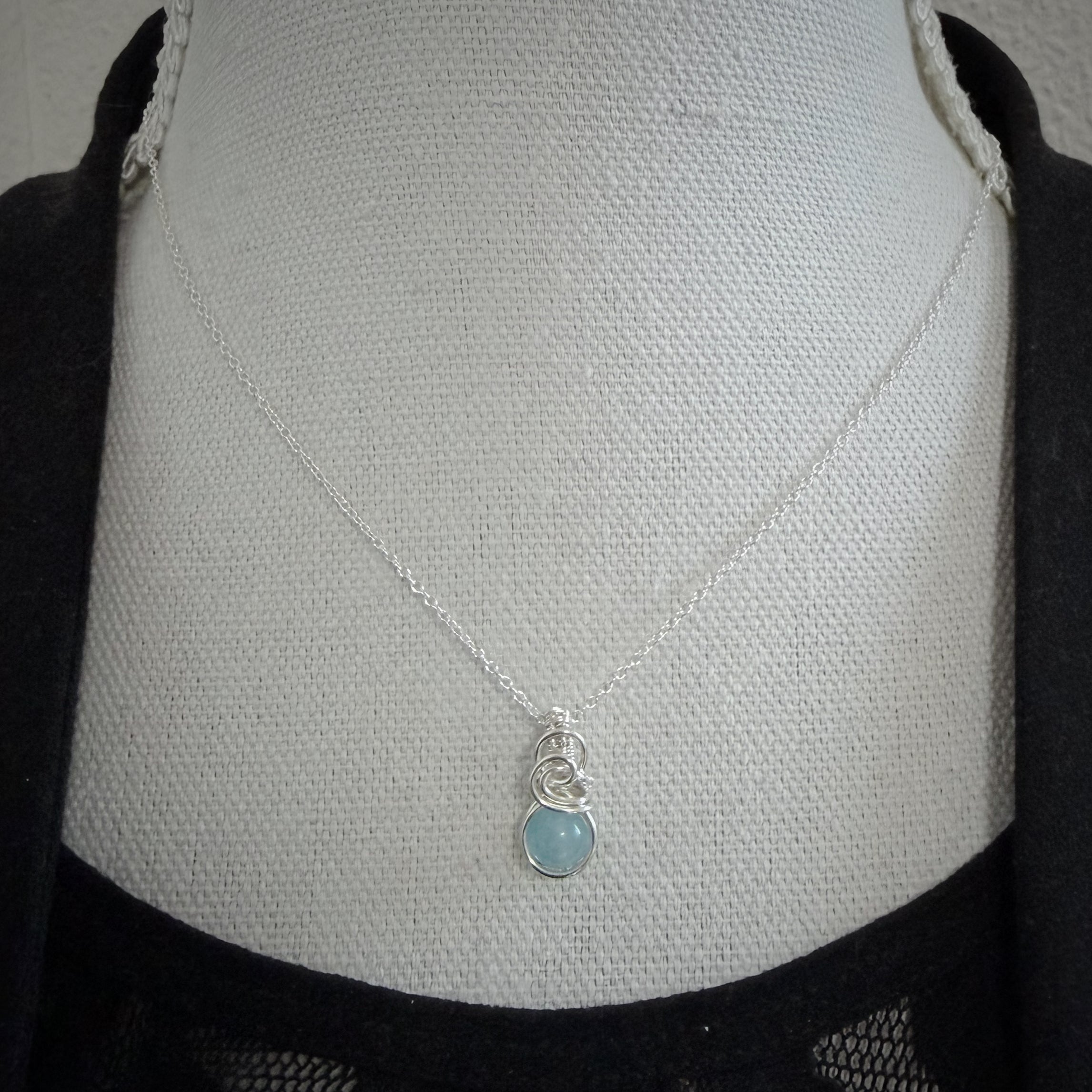 Klein sierlijk aquamarijn hangertje van zilver hangend aan een buste