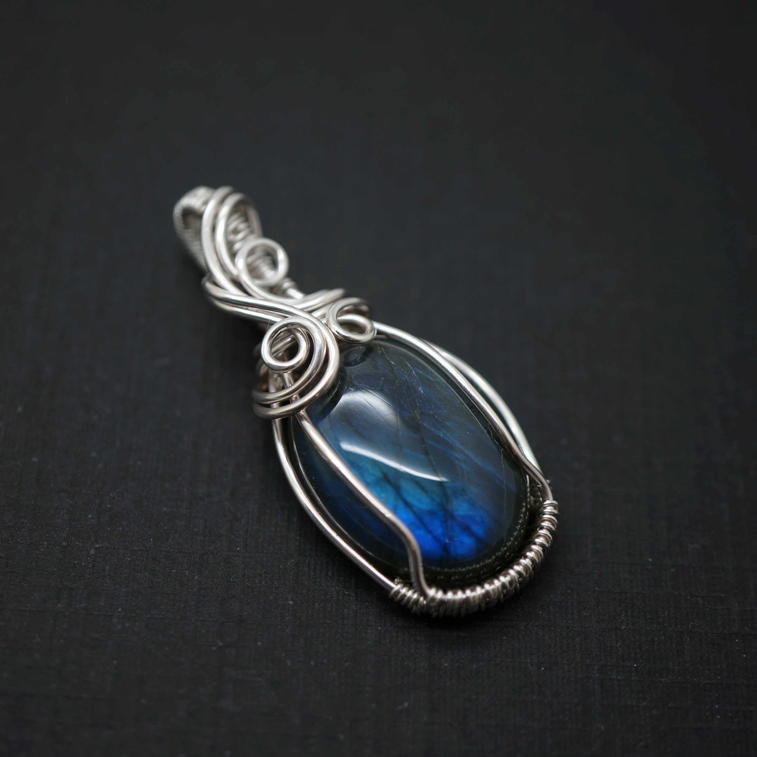 Labradoriet hanger met blauwe glans in een sterling zilveren setting, schuin van boven gefotografeerd.