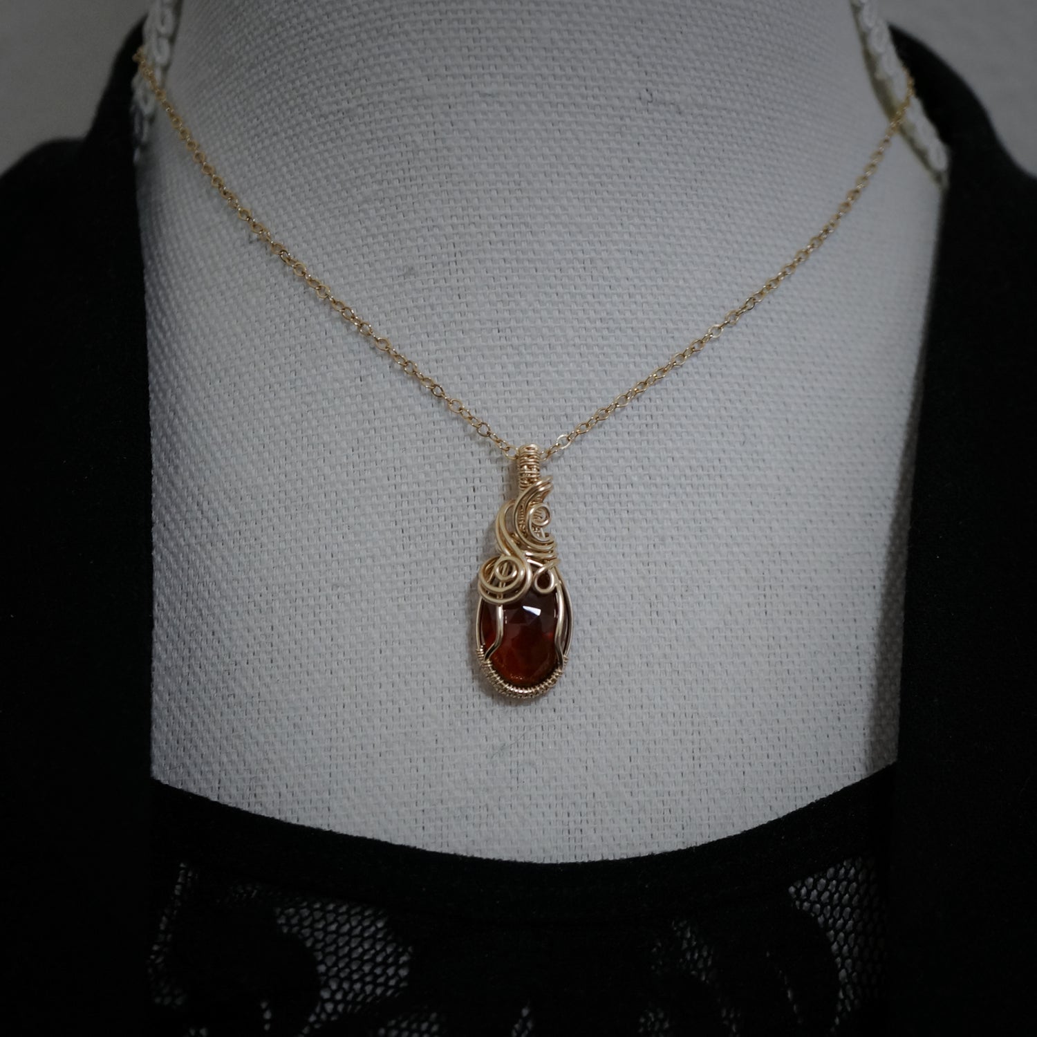 Hanger met spessartien granaat aan een 14k gold filled ketting gepresenteerd op een buste.