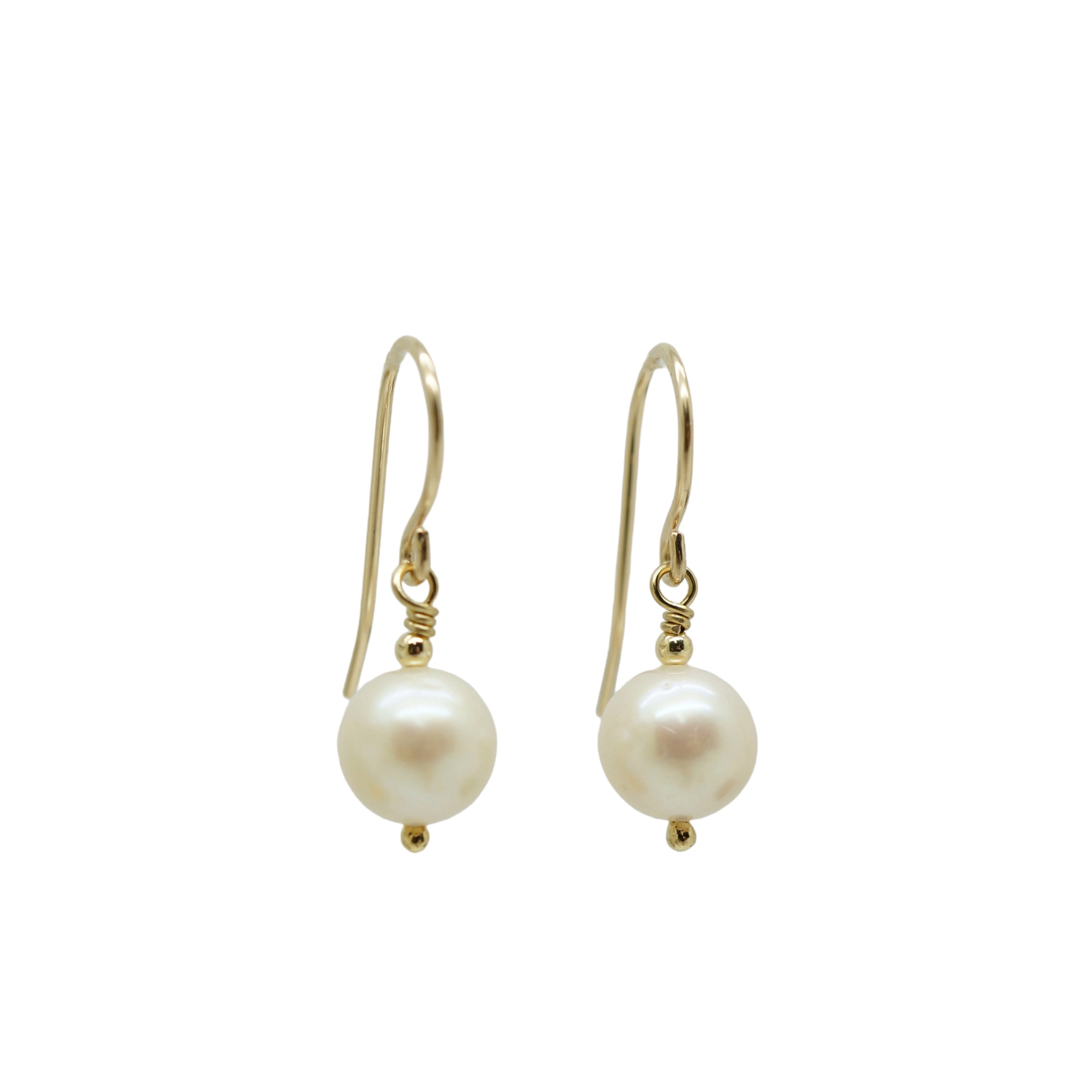Staande weergave van elegante 14k gold filled oorbellen met witte zoetwaterparels, handgemaakt design.