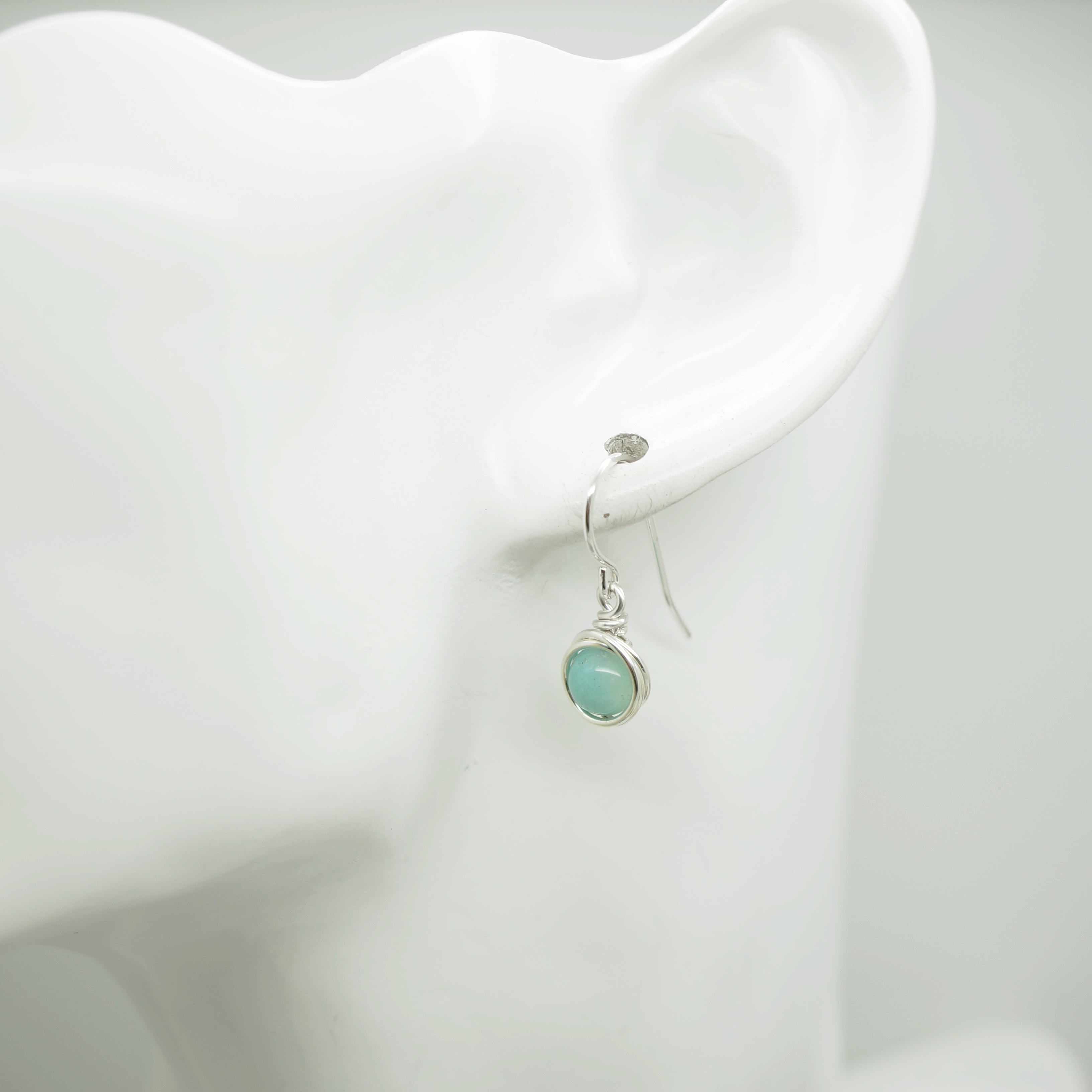 Zilveren Amazoniet oorbel gedragen aan een oormodel, elegant ontwerp van Atelier Blaauw.