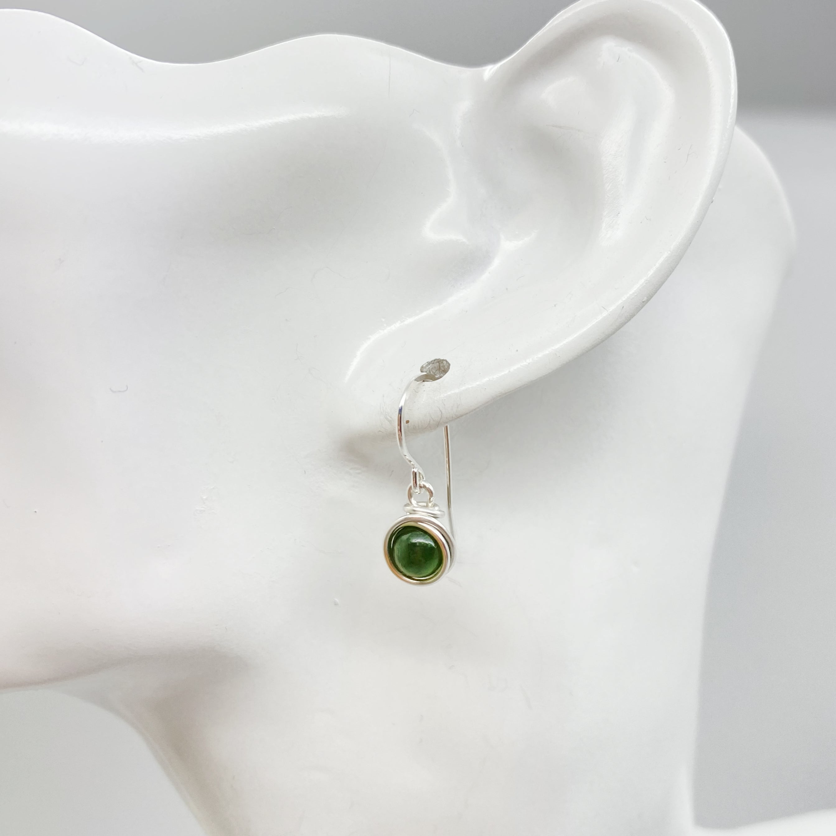 Zilveren oorbel met nefriet jade gedragen in het oor subtiel en elegant