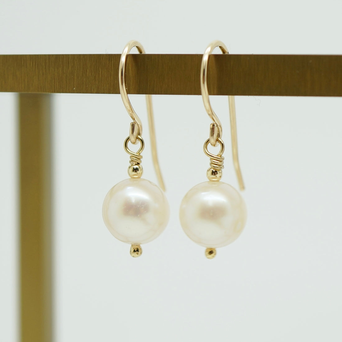 Klassieke handgemaakte 14k gold filled oorbellen met witte zoetwaterparel, elegant en tijdloos design.