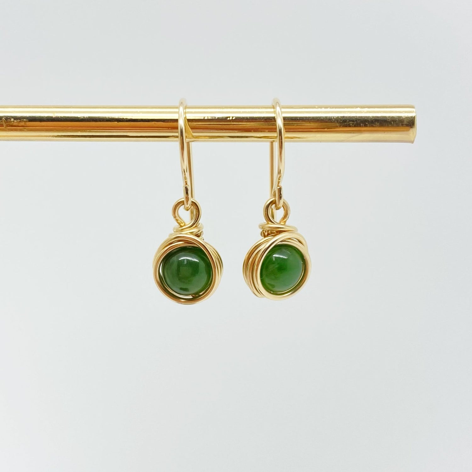 Vooraanzicht van 14k gold filled oorbellen met donkergroene nefriet jade edelstenen