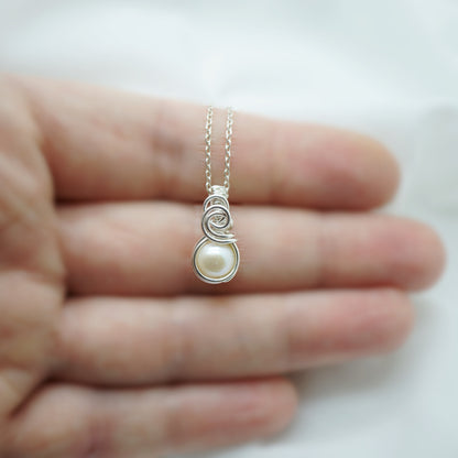 Sterling zilveren parelhanger minimalistisch design op een hand