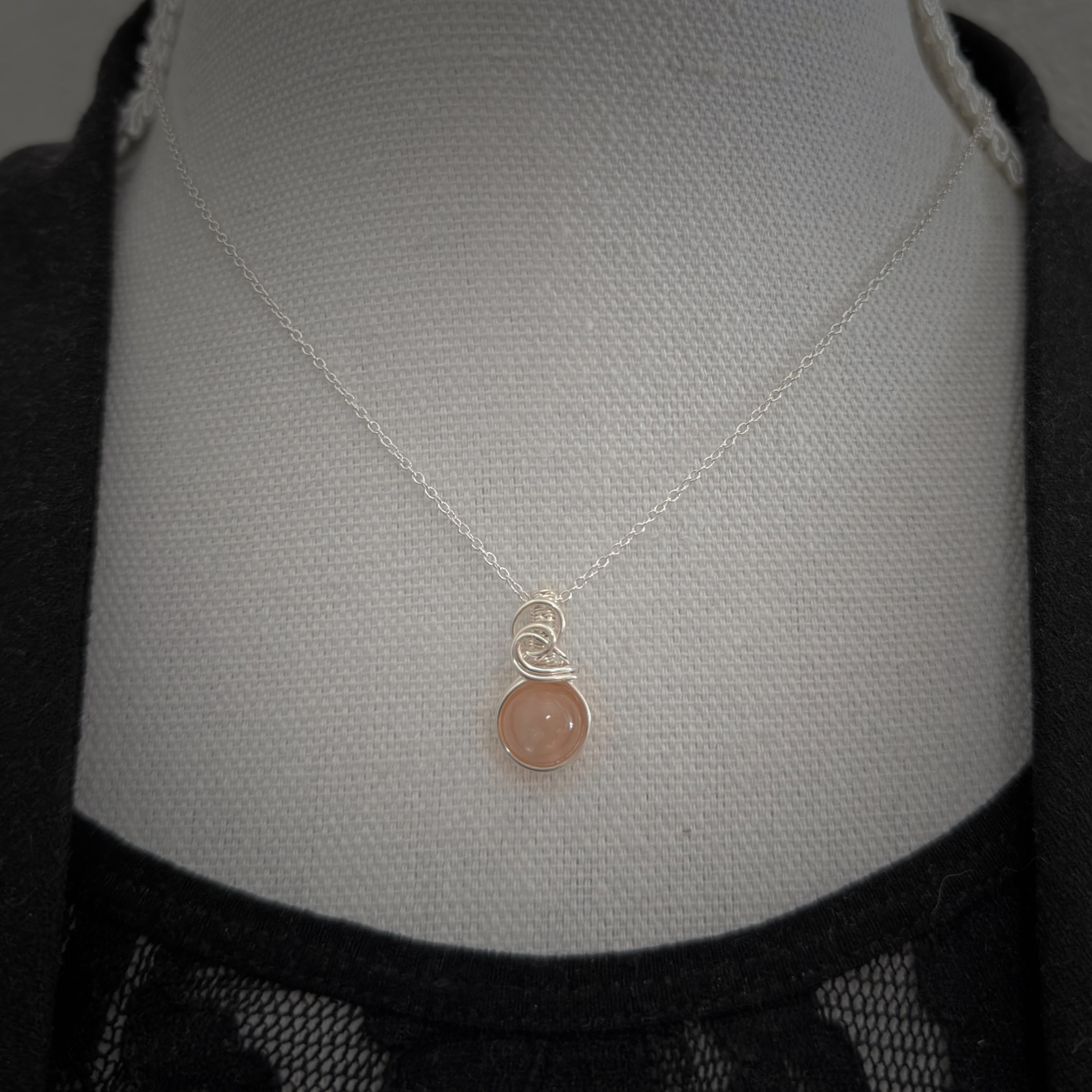 Sierlijke zilveren wire wrap hanger met perzik maansteen