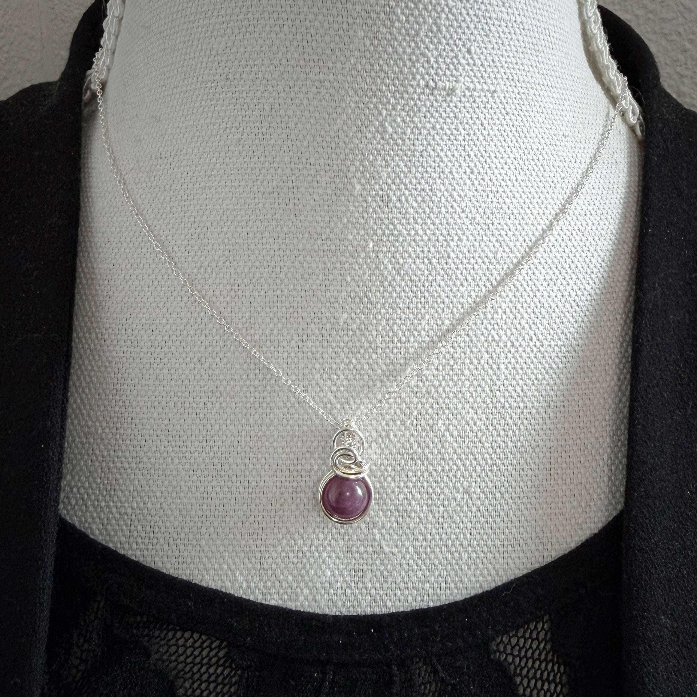 Sierlijke sterling zilveren wire wrap hanger met robijn
