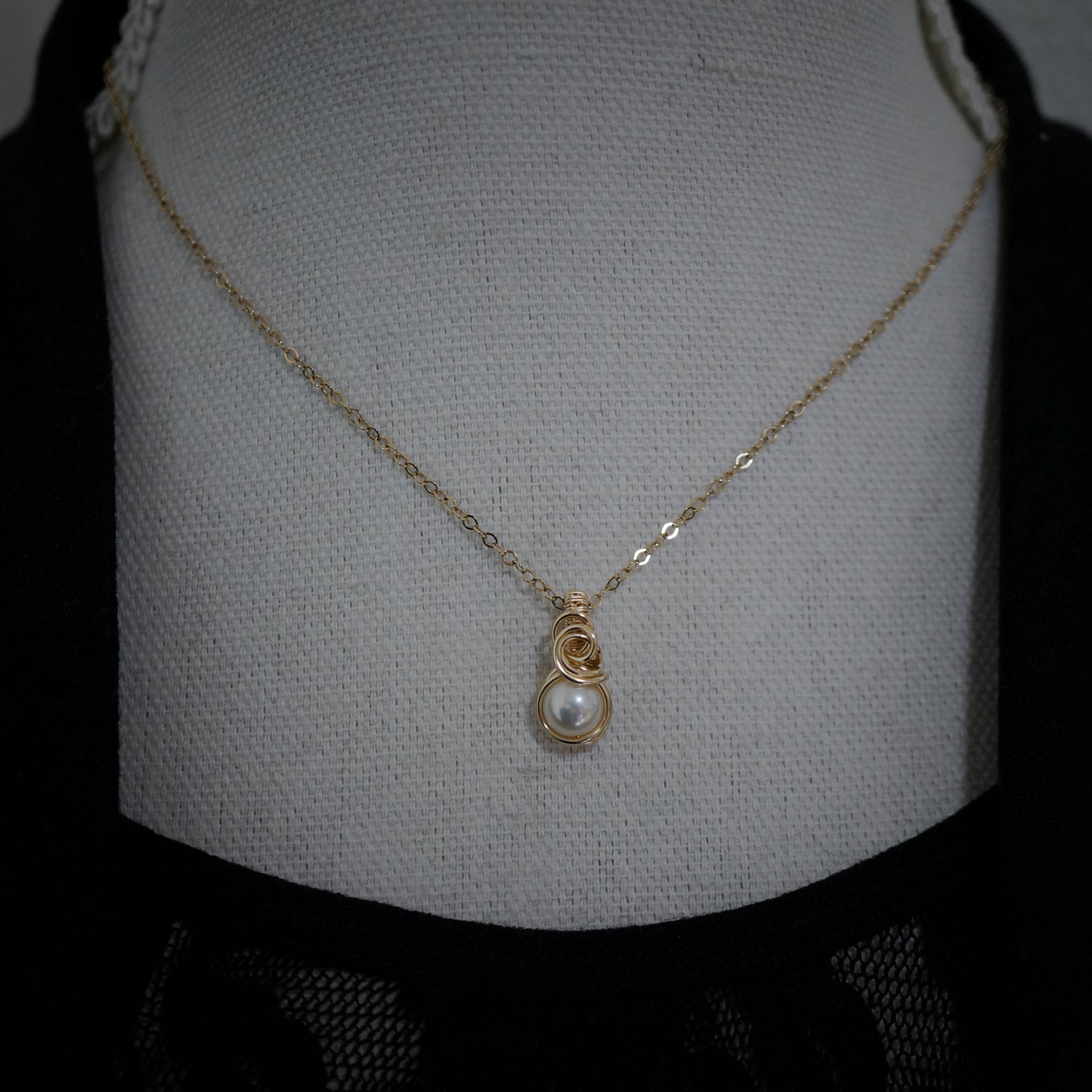 Gold filled parelhanger gefotografeerd op een buste