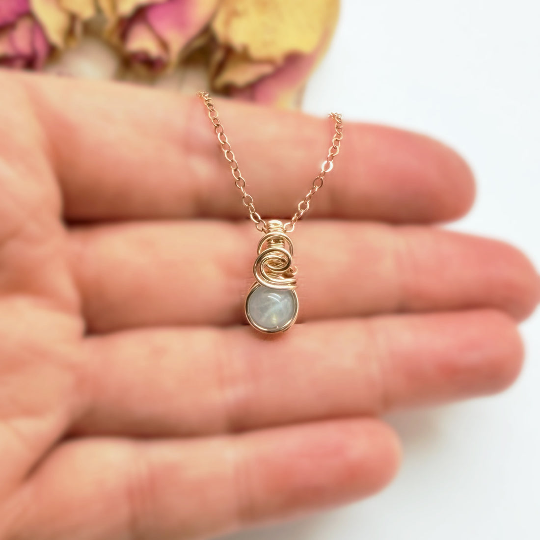 Klein handgemaakt aquamarijn hangertje van 14k gold filled getoond op de hand