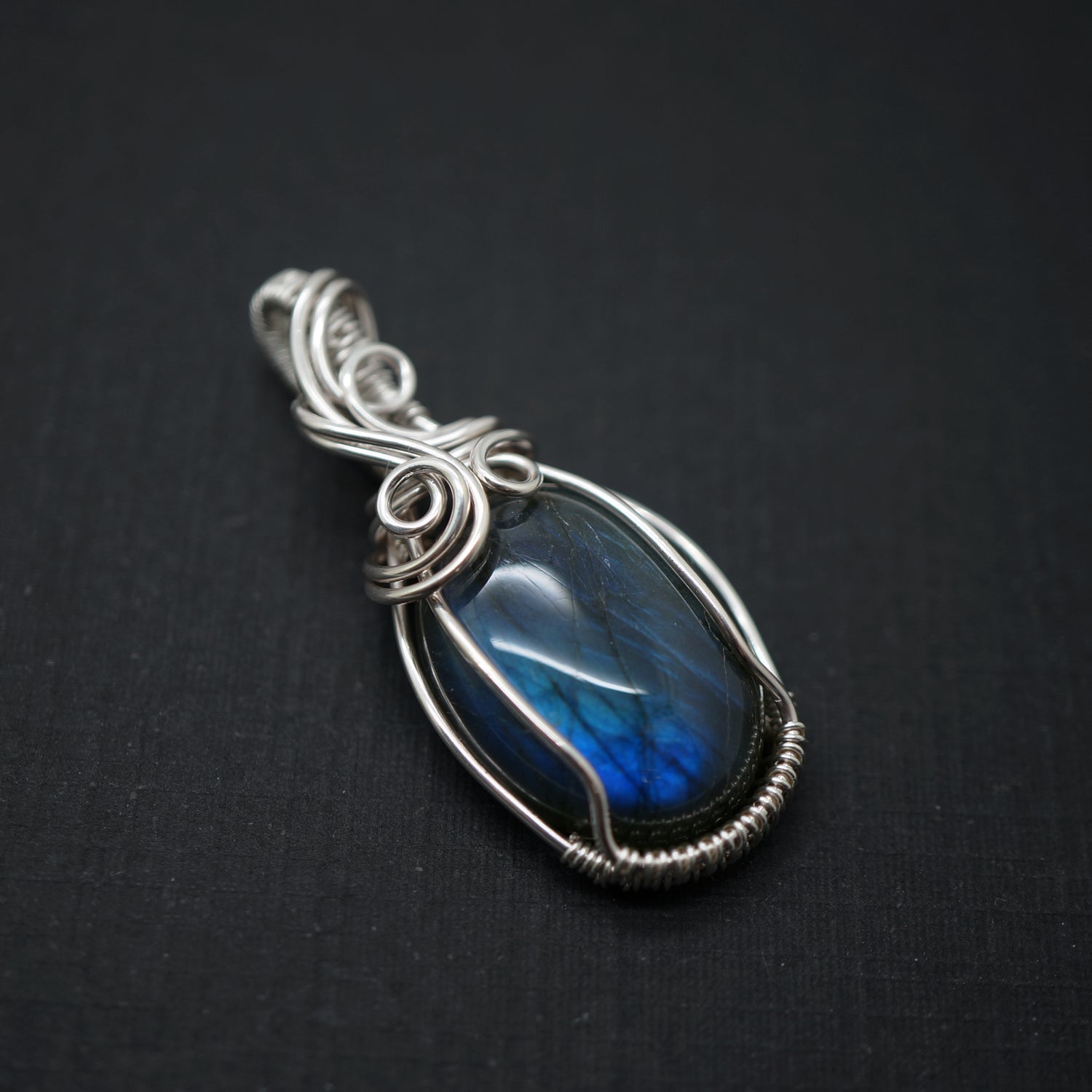 Labradoriet hanger met blauwe glans in een sterling zilveren setting, schuin van boven gefotografeerd.