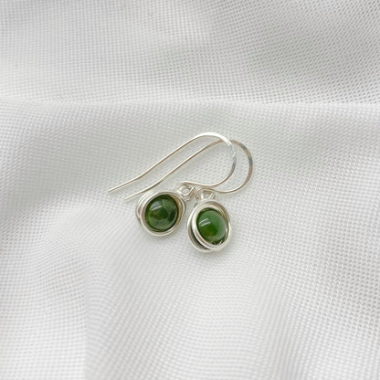 Detailfoto van zilveren oorbellen met nefriet jade en gladde zetting