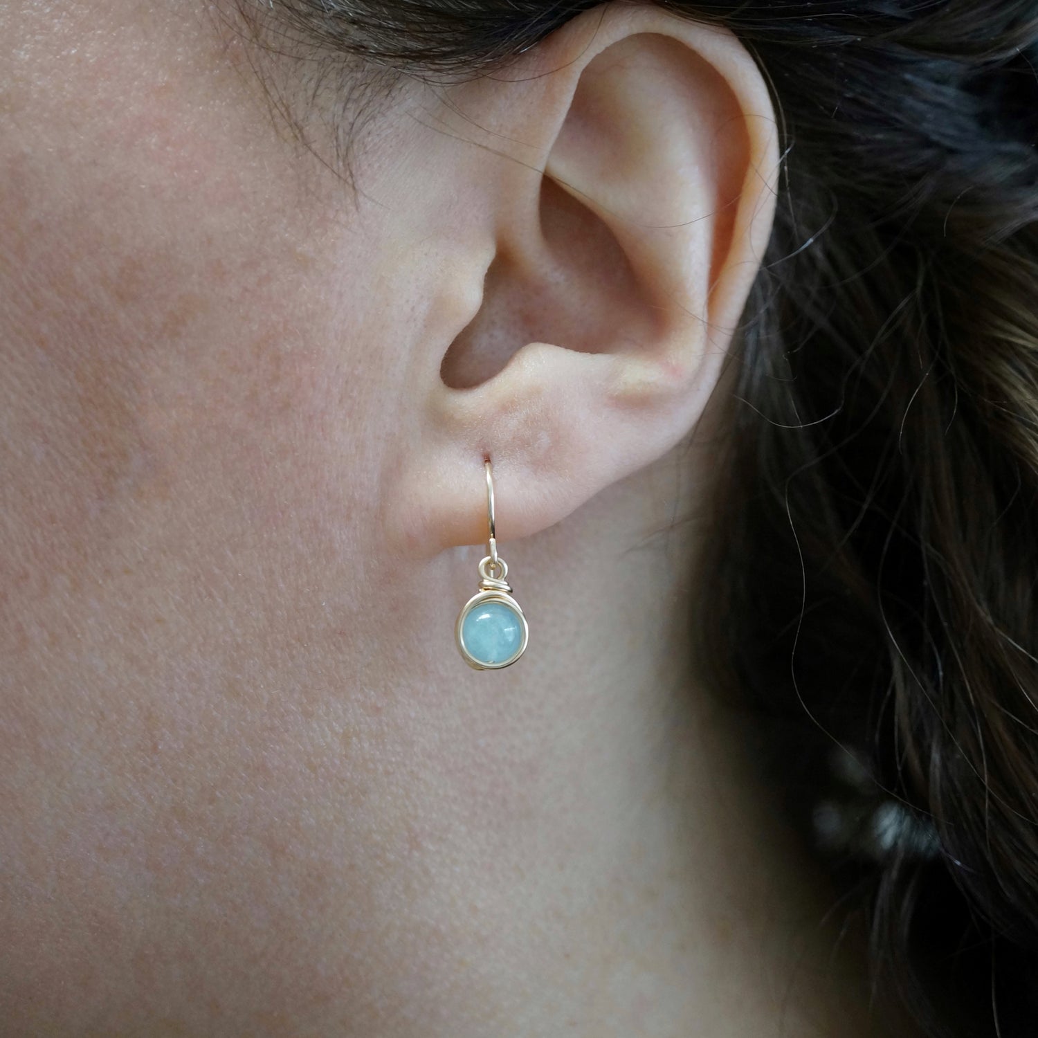 Oorbel gedragen in het oor: 14k gold filled ontwerp met lichtblauwe Aquamarijn edelsteen, elegant en verfijnd.