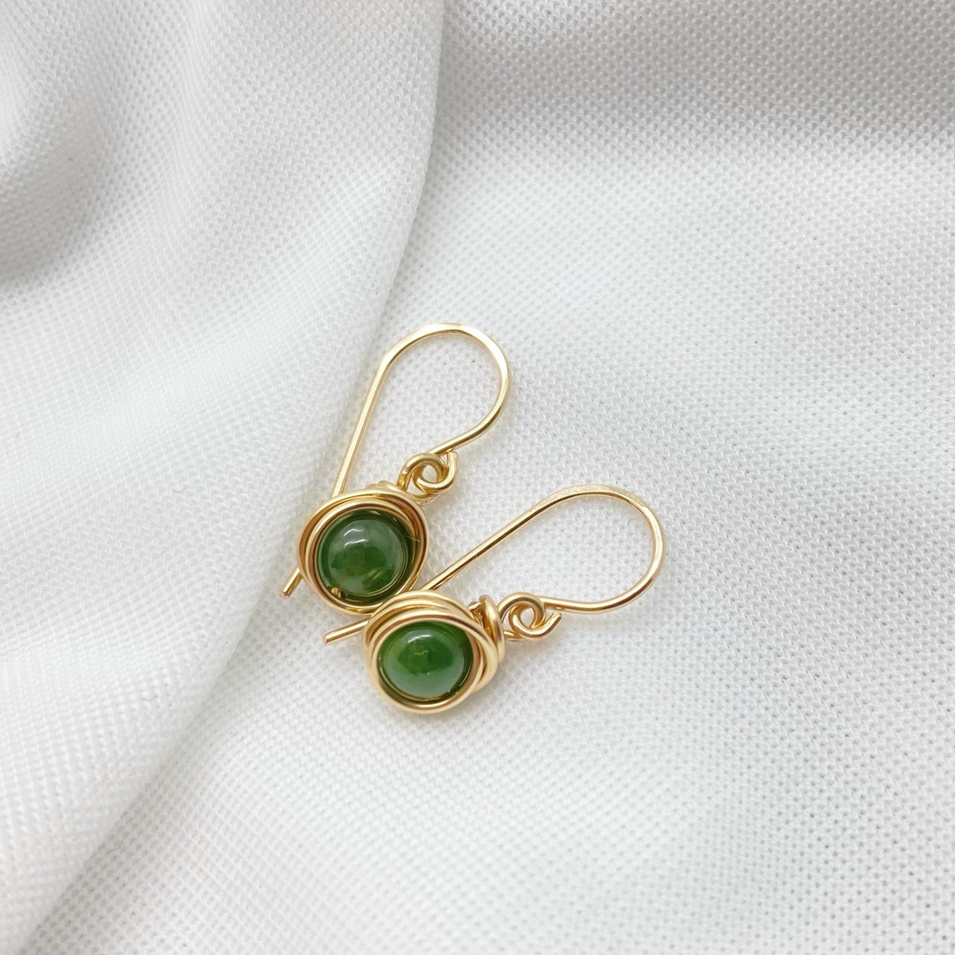 Oorbellen met nefriet jade liggend gefotografeerd zodat vorm en glans zichtbaar worden