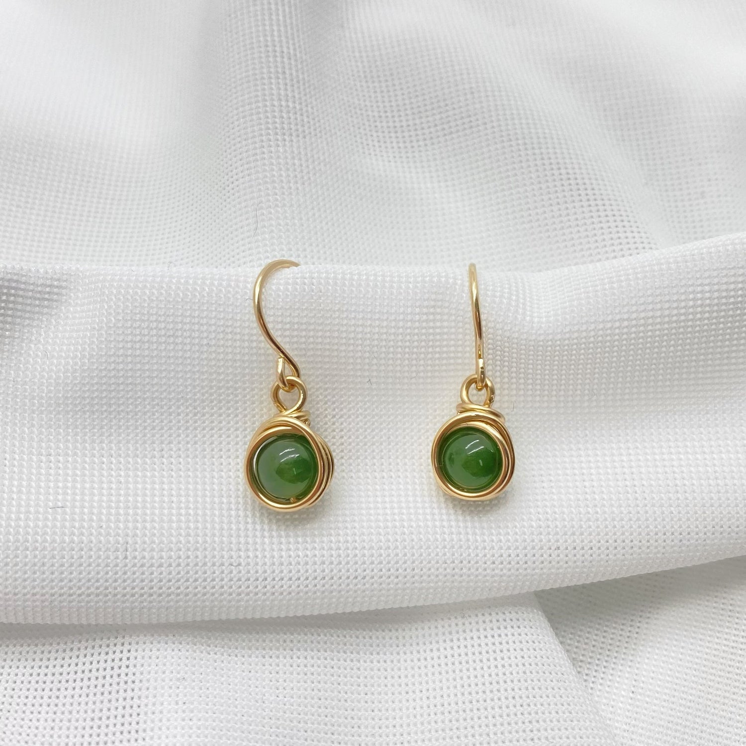 Oorbellen met nefriet jade gefotografeerd op een witte achtergrond