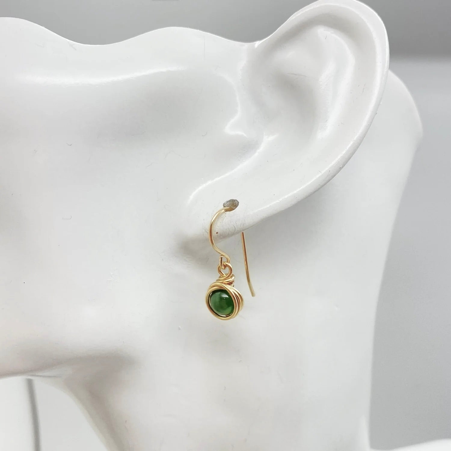 Oorbellen met nefriet jade van zijaanzicht aan mannequin hoofd