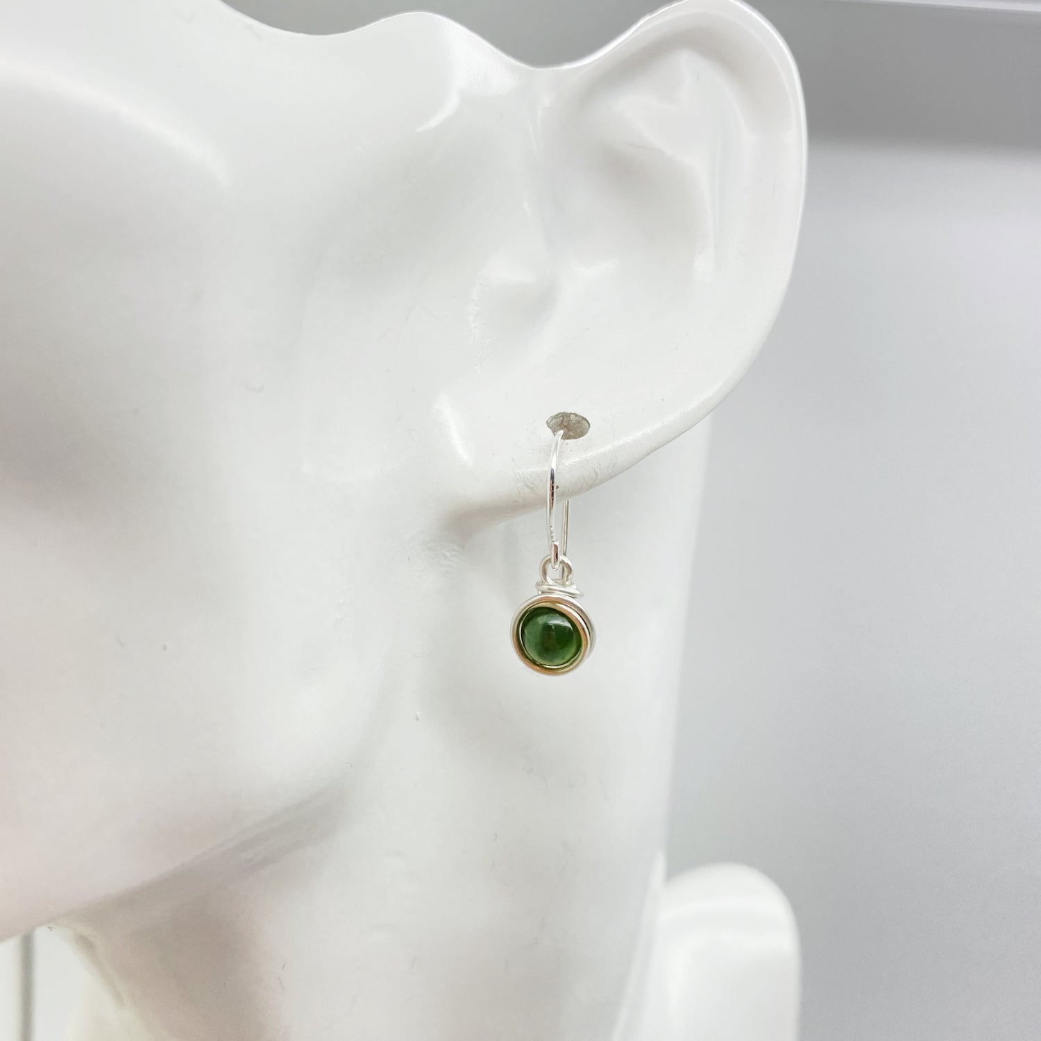 Zilveren oorbel met nefriet jade gezien van voren tijdens het dragen